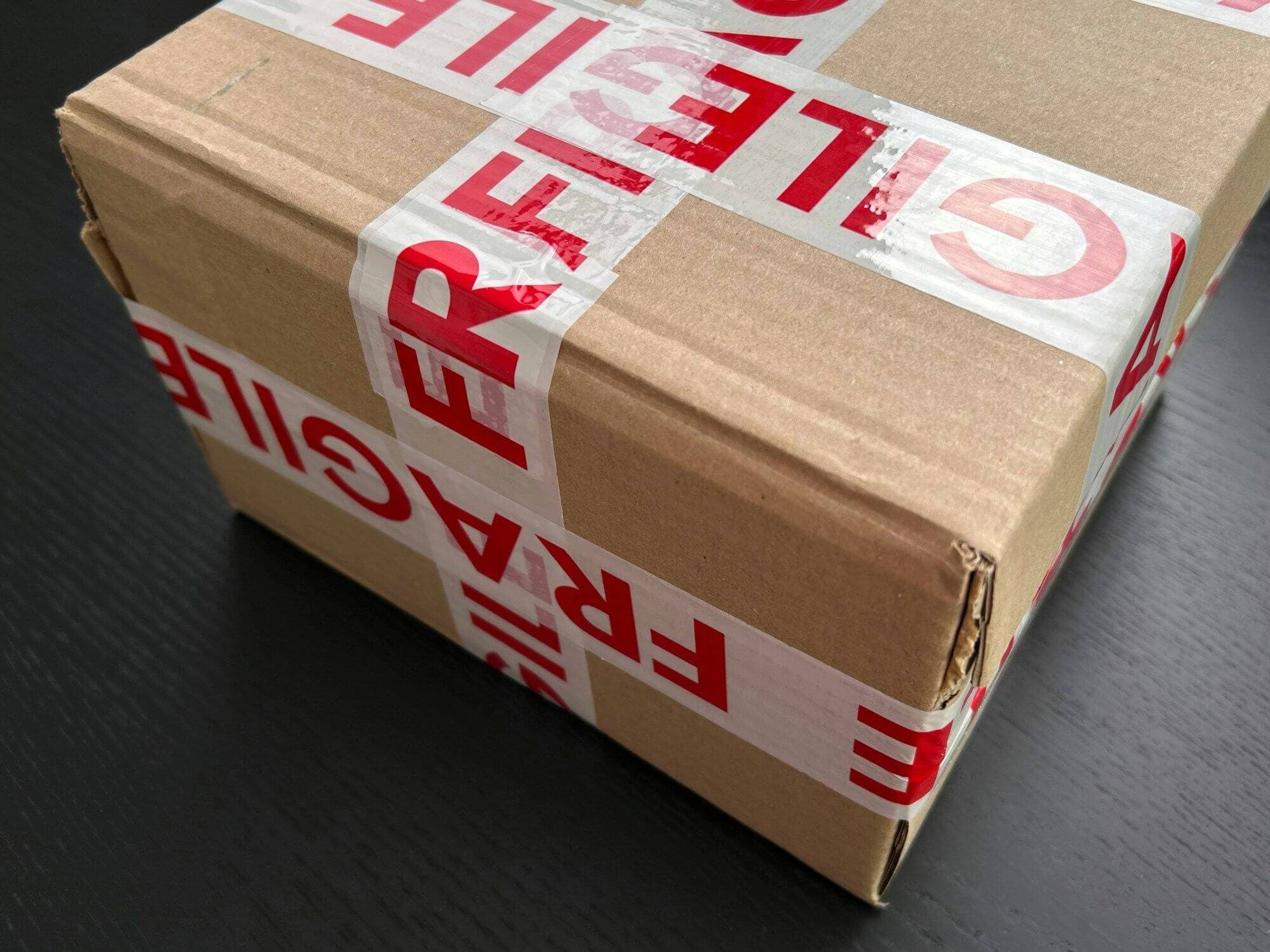 Parcel wrapped in red fragile tape
