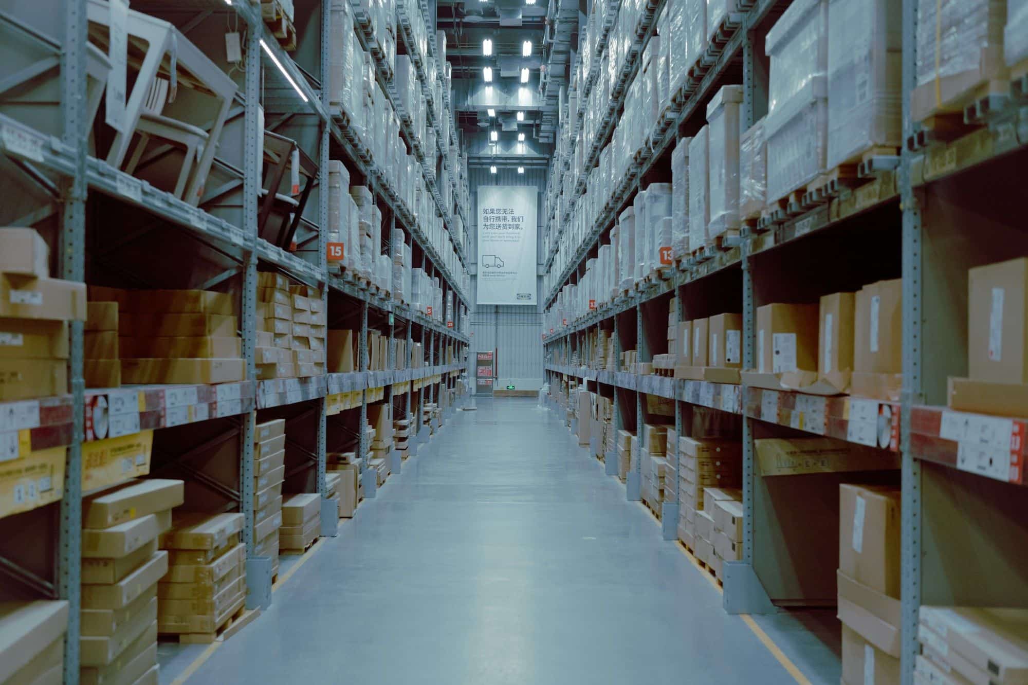 Long warehouse aisle with high racks stacked with cartons